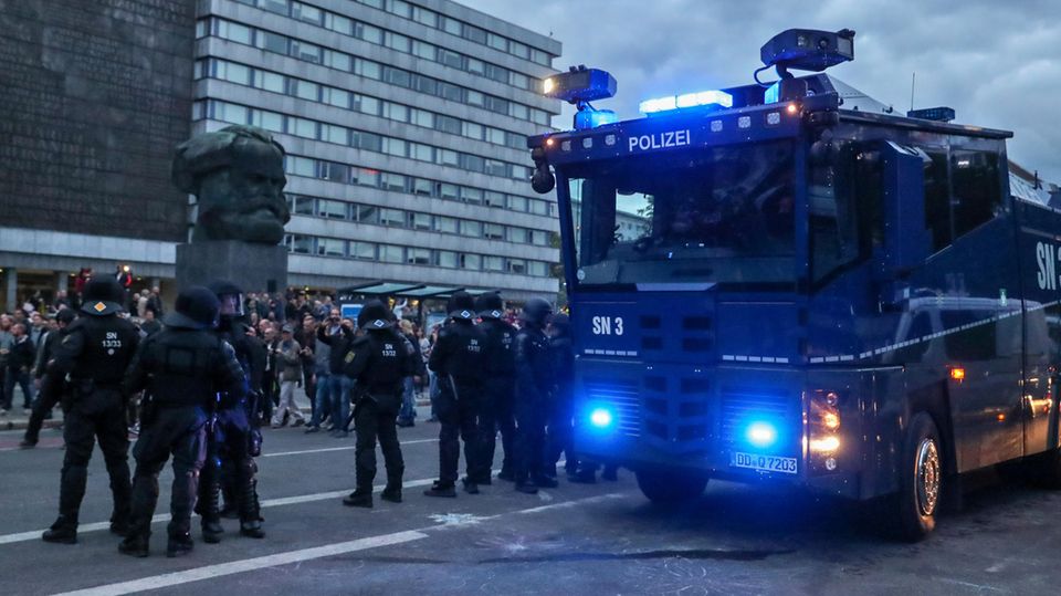 Ein Wasserwerfer und beamte der Polizei am Rande einer Demonstration am Karl-Marx-Monument in Chemnitz