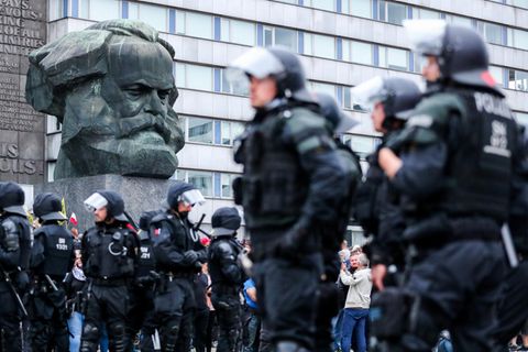 Polizei steht nach den rechten Krawallen unter der Karl-Marx-Büste in Chemnitz