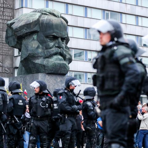 Polizei steht nach den rechten Krawallen unter der Karl-Marx-Büste in Chemnitz