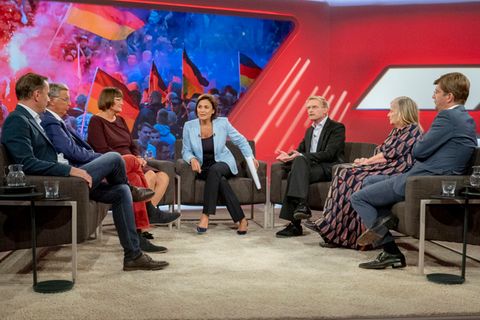 In einem TV-Studio sitzt Sandra Maischberger in der Mitte, links von ihr zwei Männer und eine Frau, rechts ebenfalls