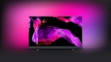 Satte Bässe ab Werk  Schlanker Fernseher, flacher Sound. Das ist der leidige Kompromiss der schicken Geräte. Um das zu ändern, hat sich Philips mit den Sound-Experten von Bowers & Wilkins zusammen getan. Der Philips OLED+ 903 hat eine Soundbar fest verbaut. Nach ersten Berichten liefert der schmale Balken am unteren Rand beeindruckende Bässe und sogar Raumklang. Mit bis zu 1000 Nit soll der 903 zudem einer der hellsten OLED-TVs am Markt sein. Dazu gibt es wie von Philips‘ Spitzenmodellen gewohnt Ambilight. Der Preis: 2500 Euro für das Modell in 55 Zoll, 3500 Euro für den 65er. 