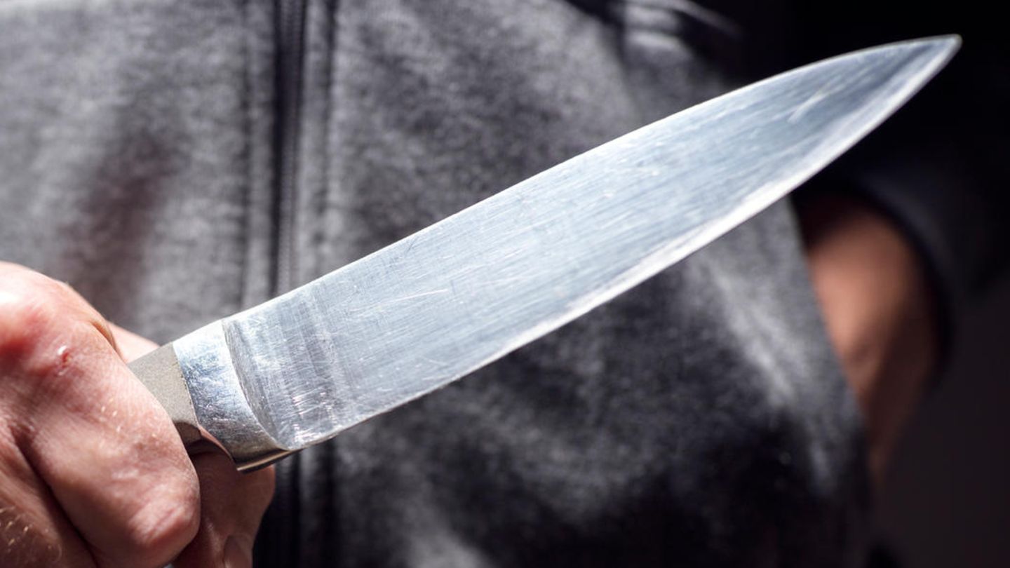 Ein Mann hält ein Messer in der Hand