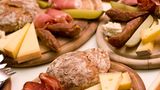 Tiroler Marend, auch bekannt als Brettljause  Marend isst man Zwischendurch. Am besten nachmittags. Eignet sich aber auch als Hauptmahlzeit. Auf einer Alm darf die Brettljause nicht fehlen. Sie besteht meist daraus, was auf der Alm hergestellt wird. Also Käse, Speck, Kaminwurzen, aber auch Schweinsbraten, Schmal, Kren und Bauernbrot.