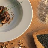 Schlutzkrapfen  Ein Koch serviert die typischen Tiroler Teigtaschen mit Bockshörndlmehl und Mohn. Gibt es auch in der weniger fancy Version mit Spinat und Topfen, also Quark, oder Rüben-Speck-Füllung in jedem guten Tiroler Gasthof.