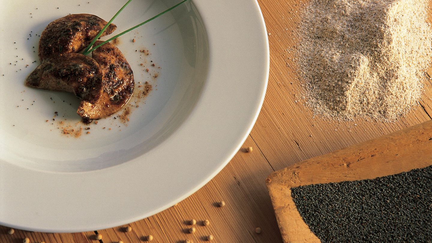 Schlutzkrapfen  Ein Koch serviert die typischen Tiroler Teigtaschen mit Bockshörndlmehl und Mohn. Gibt es auch in der weniger fancy Version mit Spinat und Topfen, also Quark, oder Rüben-Speck-Füllung in jedem guten Tiroler Gasthof.