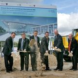 Symbolischer Spatenstich  Am 5. September 2006 begann der Bau des neuen Hauptstadtflughafens, damals noch Airport Berlin Brandenburg International (BBI) genannt. Die Herren stehen vor einem Schild, das die Eröffnung für den Oktober 2011 vorsieht.