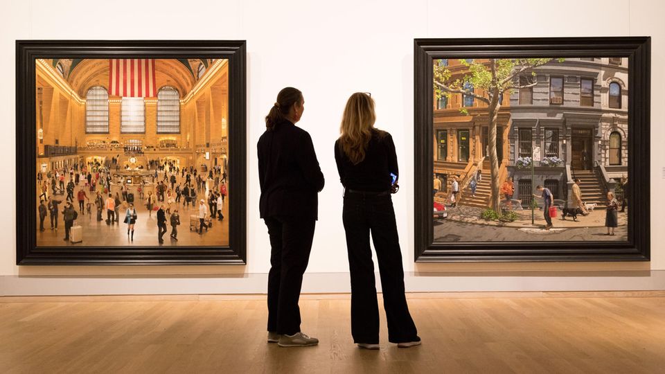 Kunsthalle Emden:  In der Ausstellung "The American Dream" stehen zwei Besucher vor den Gemälden "Grand Central Terminal" und "A Bend in the Road" des Malers Stone Roberts.