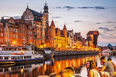 Danzigs Skyline am Abend: Gemeinschaftlich genießen Jugendliche an der Motława den Blick auf die glänzende Uferstraße.