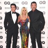 Designerin Donatella Versace schmückte sich mit den Schauspielern Richard Madden (l.) und Luke Evans. Ihr buntes Kleid war selbstverständlich eine Eigenkreation.