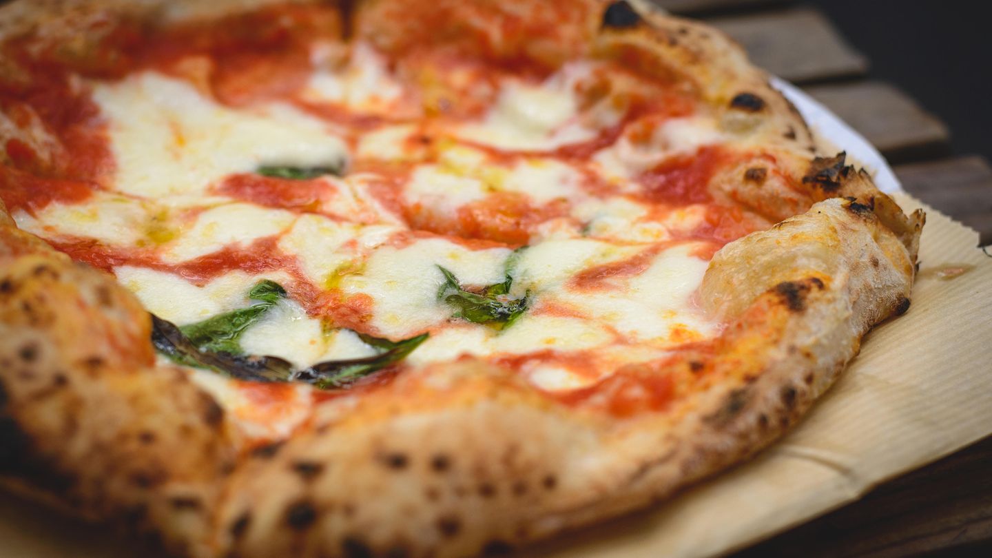 Eine Käsepizza liegt auf einem Tisch