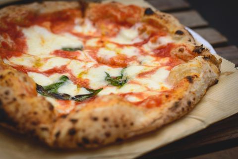 Eine Käsepizza liegt auf einem Tisch