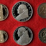 Außengrenze, ständig geöffnet  Wer von der Via della Conciliazione auf den Petersplatz tritt, hat die EU-Außengrenze überquert. Denn der Vatikan gehört der Europäischen Union nicht an – und darf ihr auch nicht beitreten, weil er keine Demokratie ist. Kontrollen gibt es aber nicht, die Grenze ist Tag und Nacht geöffnet. Dank eines Vertrags mit Italien darf der Vatikan den Euro trotzdem als Währung nutzen und eigene Münzen mit dem Wappen des Papstes prägen.