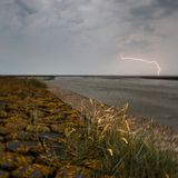Ein Blitz zuckt über den dunklen Himmel.
