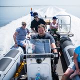 Das Team sitzt auf dem Schlauchboot.