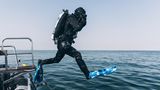 Andi springt in Tauschausstattung mit Schrittsprung vom Schlauchboot.