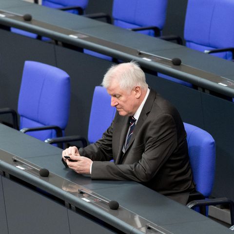 Mann im Anzug spielt auf Handy
