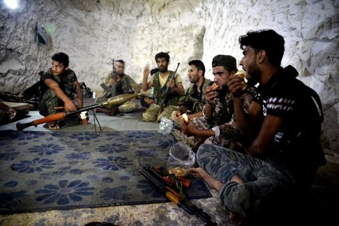 Syrien, Idlib: Kämpfer und Soldaten der Freien Syrischen Armee sitzen in einer Höhle.