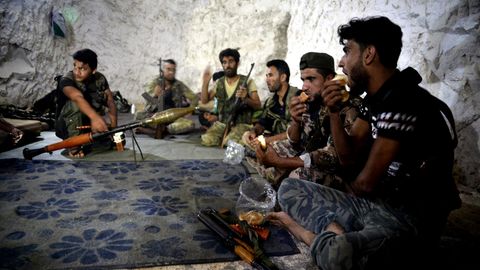 Syrien, Idlib: Kämpfer und Soldaten der Freien Syrischen Armee sitzen in einer Höhle.