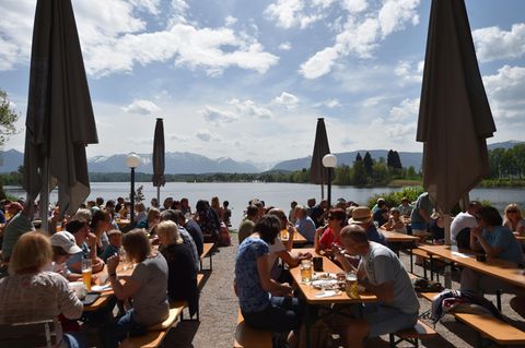 Besucher des Biergartens am Staffelsee genießen das sonnige Wetter