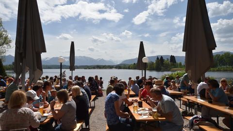 Besucher des Biergartens am Staffelsee genießen das sonnige Wetter