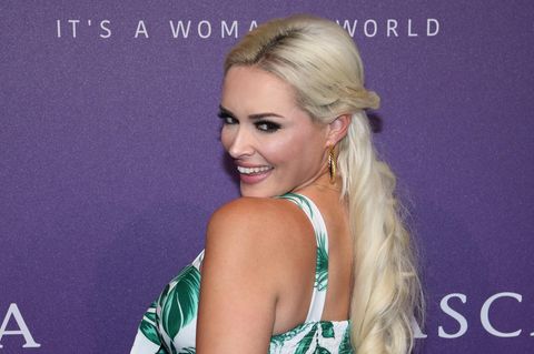 Vor einer violetten Wand lächelt Daniela Katzenberger über ihre linke Schulter in die Kameras. Sie trägt ein Top und eine Hose