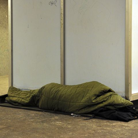 Ein Obdachloser schläft auf einem U-Bahnsteig in Berlin