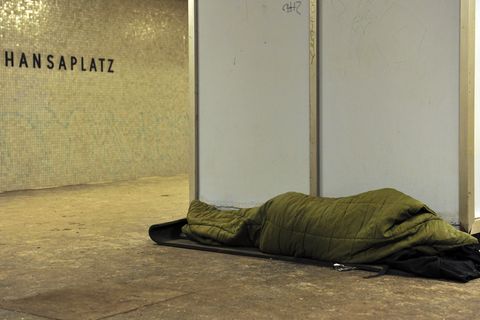 Ein Obdachloser schläft auf einem U-Bahnsteig in Berlin