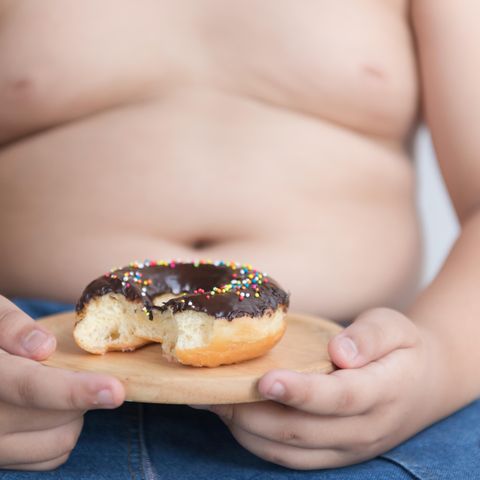 Kind hält einen Schokoladen-Donut
