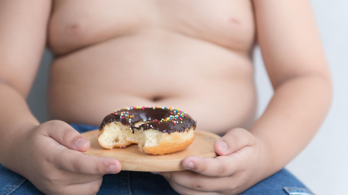 Kind hält einen Schokoladen-Donut