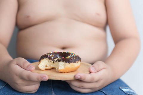 Kind hält einen Schokoladen-Donut
