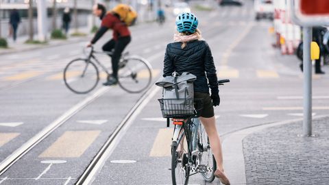 Eine Fahrradfahrerin hält im Straßenverkehr an einer Kreuzung