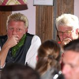 Zwei Männer in Denkerpose: Boris Becker und Marcel Reif im Käferzelt