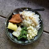 Auf einem Teller mit einem Bananenblatt als Unterlage serviert: Im Dorf Yorkin werden neben Reis auch ein Stück Hühnerfleisch sowie gekochte Maniok-Knolle aufgetischt.