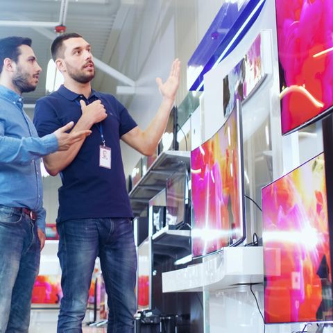 Ein Kunde lässt sich beim Fernseher-Kauf beraten