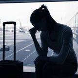 Frau sitzt am Flughafen