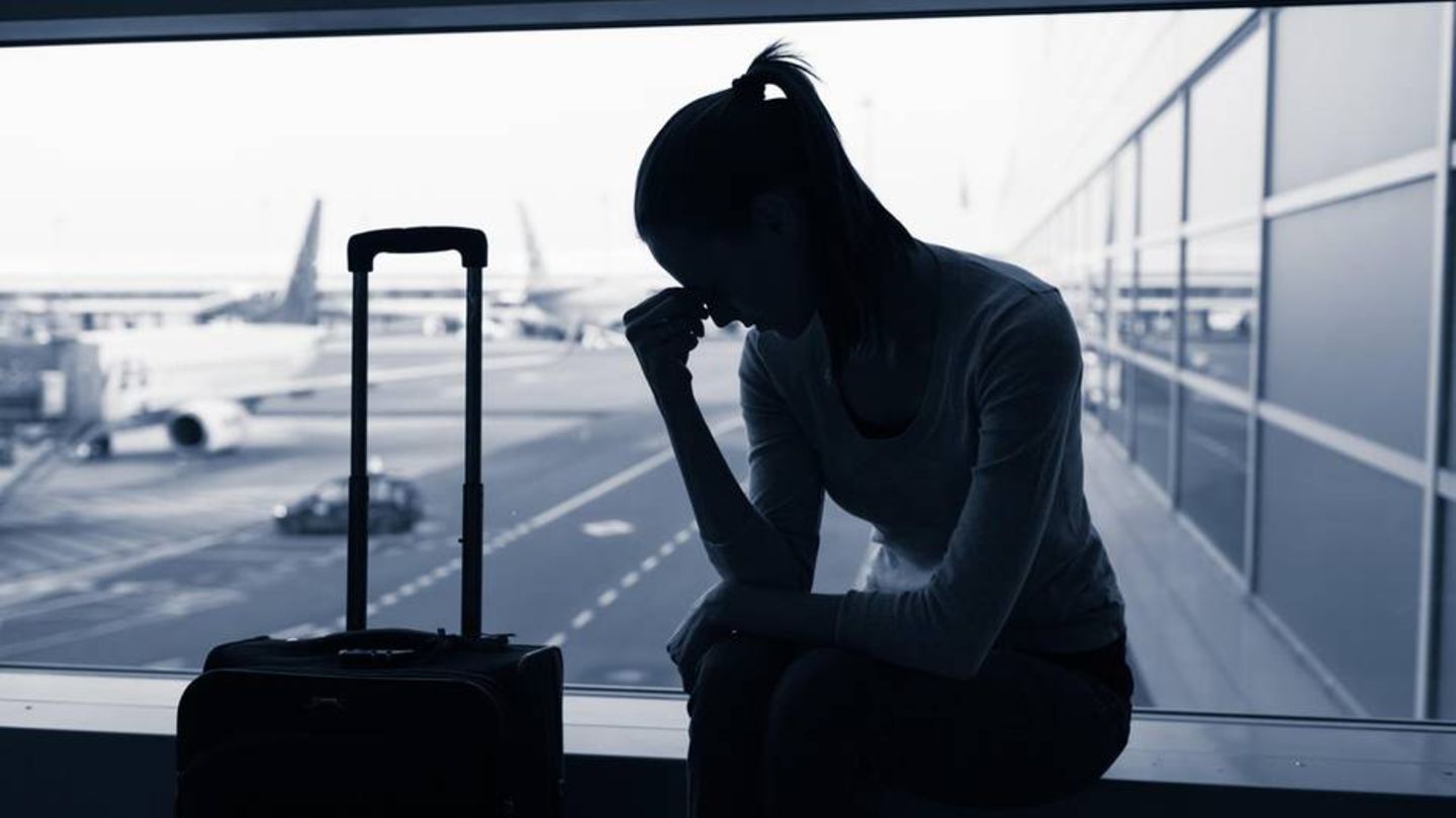 Frau sitzt am Flughafen