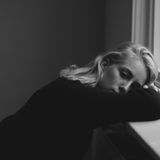 Mädchen liegt mit Kopf auf Fensterbank