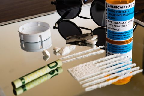 Zerstoßene Tabletten und ein gerollter Geldschein liegen auf einem Spiegel