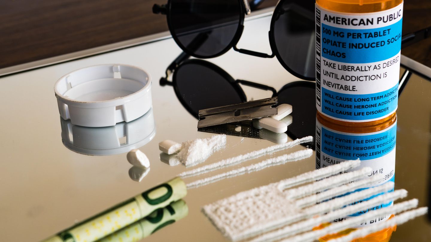 Zerstoßene Tabletten und ein gerollter Geldschein liegen auf einem Spiegel