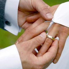 Ein steckt seiner Frau bei der Hochzeit den Ring an den Finger