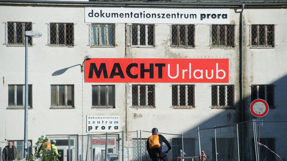 KdF-Seebad an der Ostsee: Ein Schild mit der Aufschrift "MACHT Urlaub" hängt an der Fassade des Dokumentationszentrums Prora Ein Schild mit der Aufschrift "MACHT Urlaub" hängt an der Fassade des Dokumentationszentrums Prora