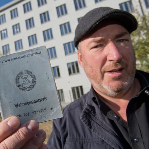 Christian Schmidt, ehemaliger DDR-Bausoldat, zeigt vor Block 5 in Prora seinen ehemaligen Wehrdienstausweis