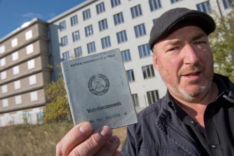 Christian Schmidt, ehemaliger DDR-Bausoldat, zeigt vor Block 5 in Prora seinen ehemaligen Wehrdienstausweis