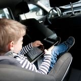 Kind nutzt Ipad im Auto