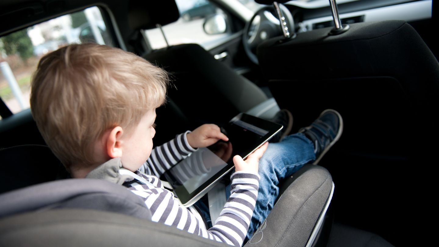 Kind nutzt Ipad im Auto Kind nutzt Ipad im Auto