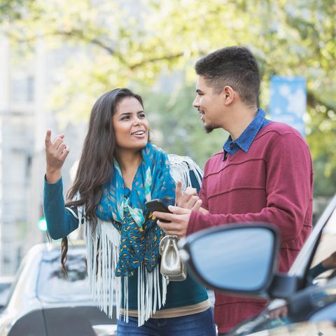 Ein Pärchen wartet am Straßenrand auf das Auto, das es telefonisch bestellt hat