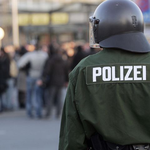 Ein Polizist steht vor einer Menschenmenge
