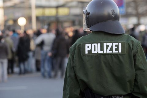 Ein Polizist steht vor einer Menschenmenge