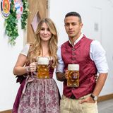 Der Spanier Thiago Alcántara und seine Frau Julia Vigas stemmen eine Maß Bier für die Fotografen