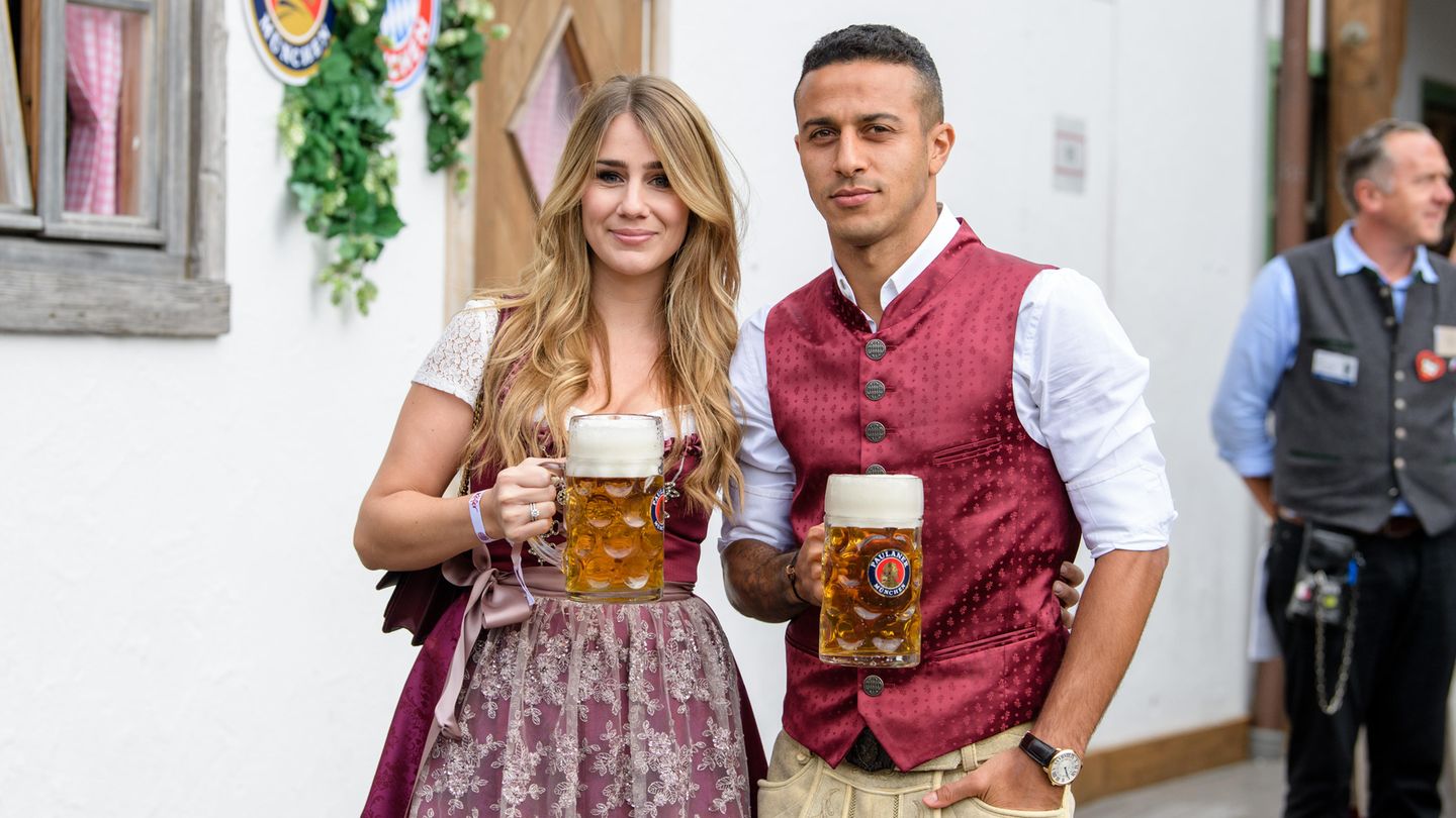 Der Spanier Thiago Alcántara und seine Frau Julia Vigas stemmen eine Maß Bier für die Fotografen